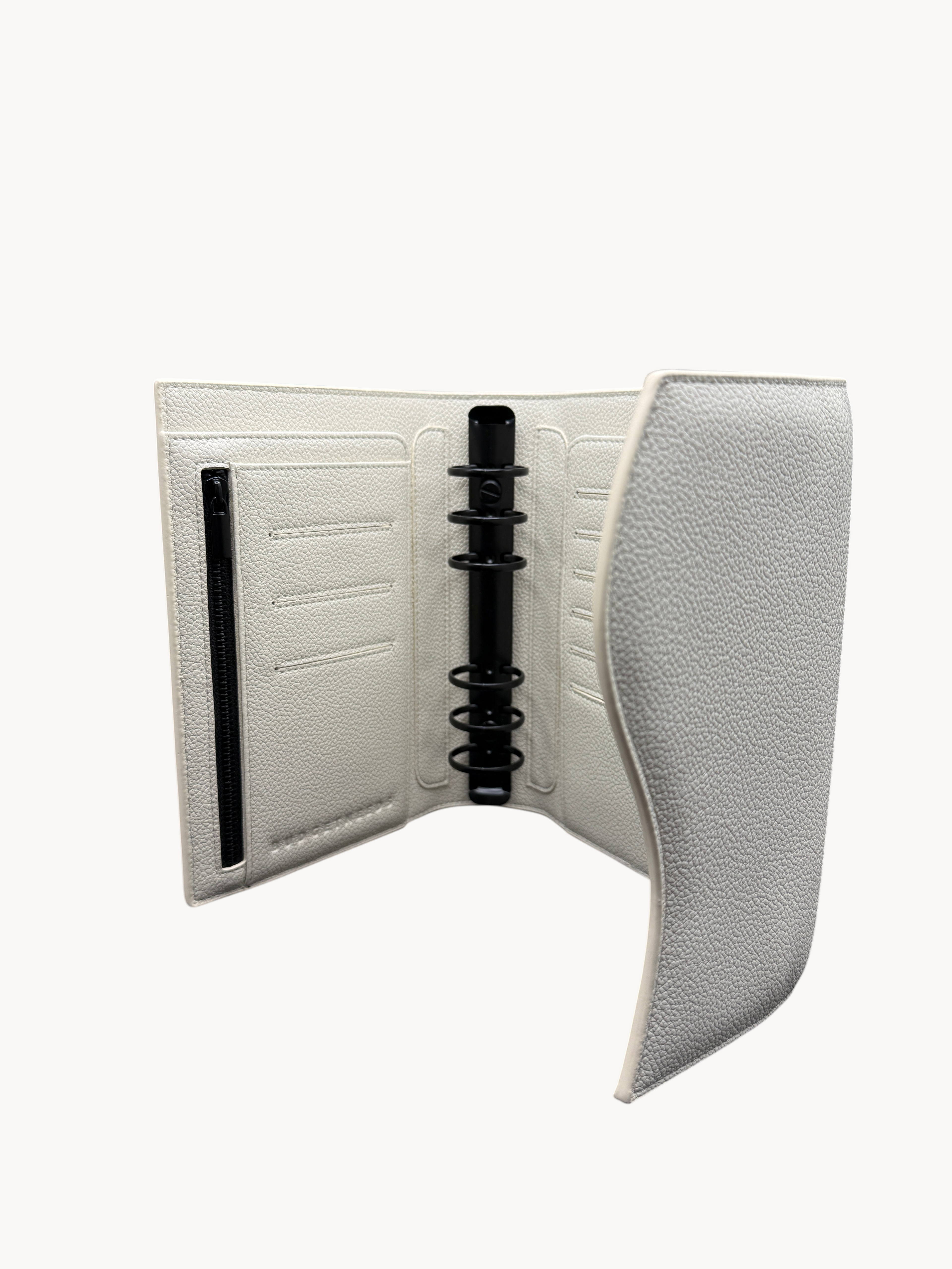 BUDGETNEEDS ™ A6 FlapLine ring binder in white textured material with matte black hardware and magnetic closure.