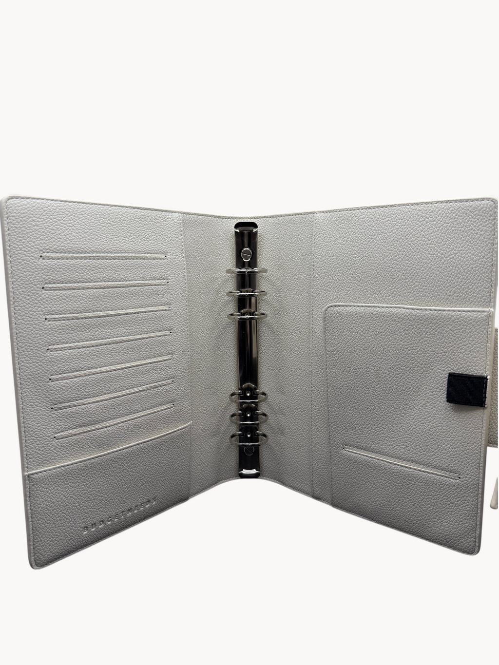 BUDGETNEEDS ™ A5 MiniFlap ring binder in cream with matte black hardware, pen holder, and interior card slots.