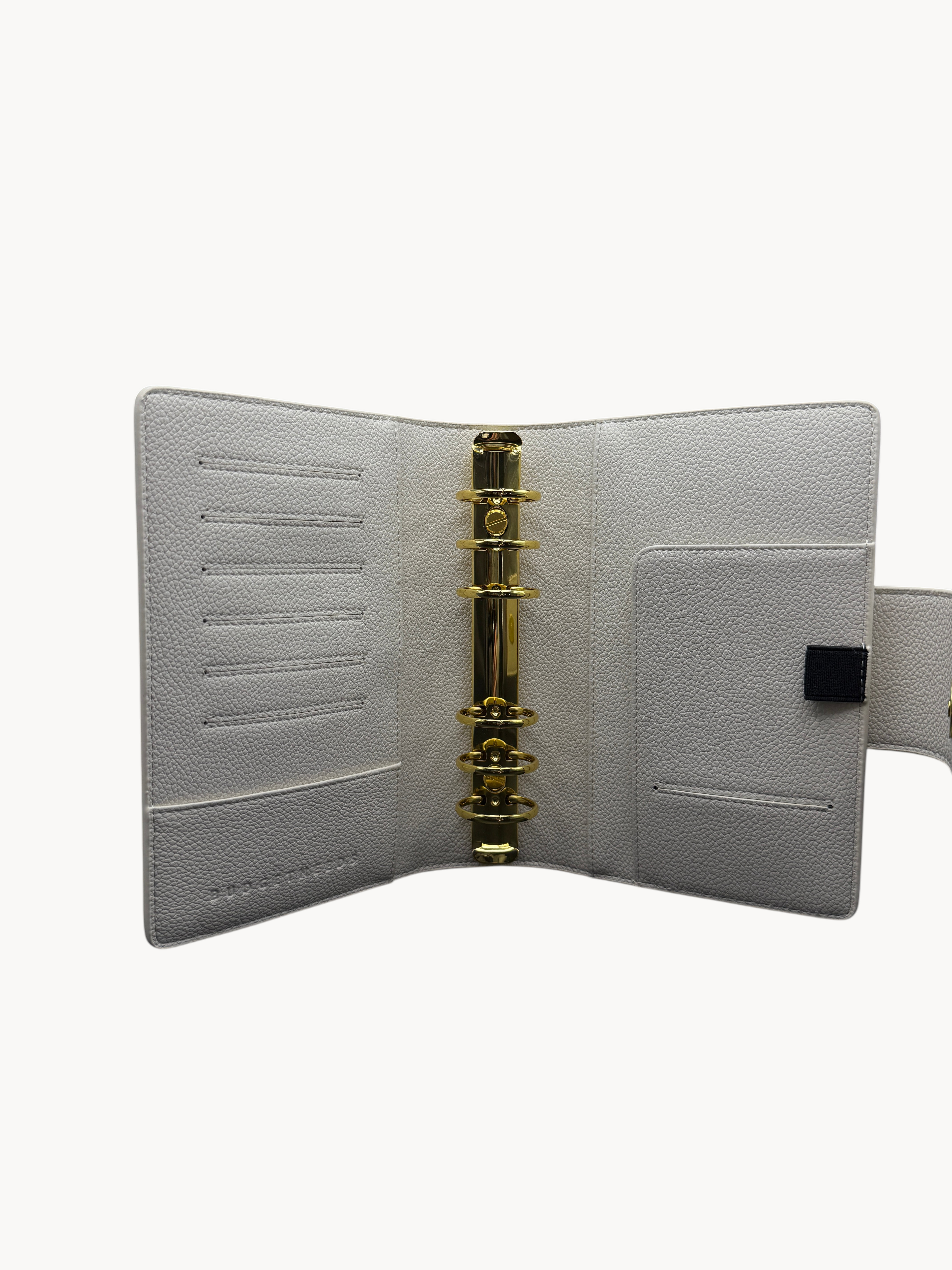 BUDGETNEEDS ™ A6 ring binder in cream with gold hardware, featuring card slots, a pen holder, and magnetic closure.