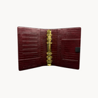 BUDGETNEEDS ™ A6 MiniFlap ring binder in ruby red crocodile-textured leather with gold hardware and pen holder.