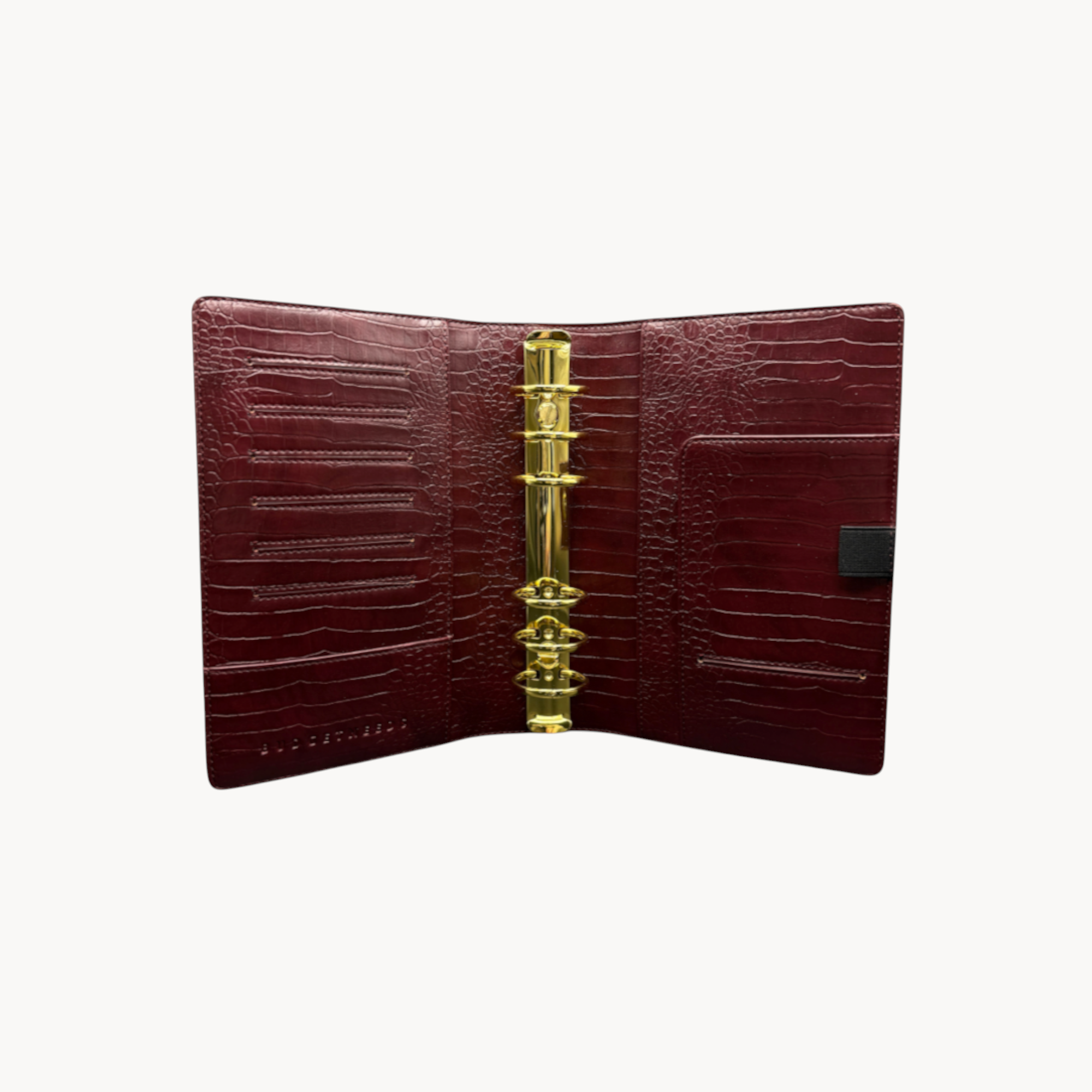 BUDGETNEEDS ™ A6 MiniFlap ring binder in ruby red crocodile-textured leather with gold hardware and pen holder.